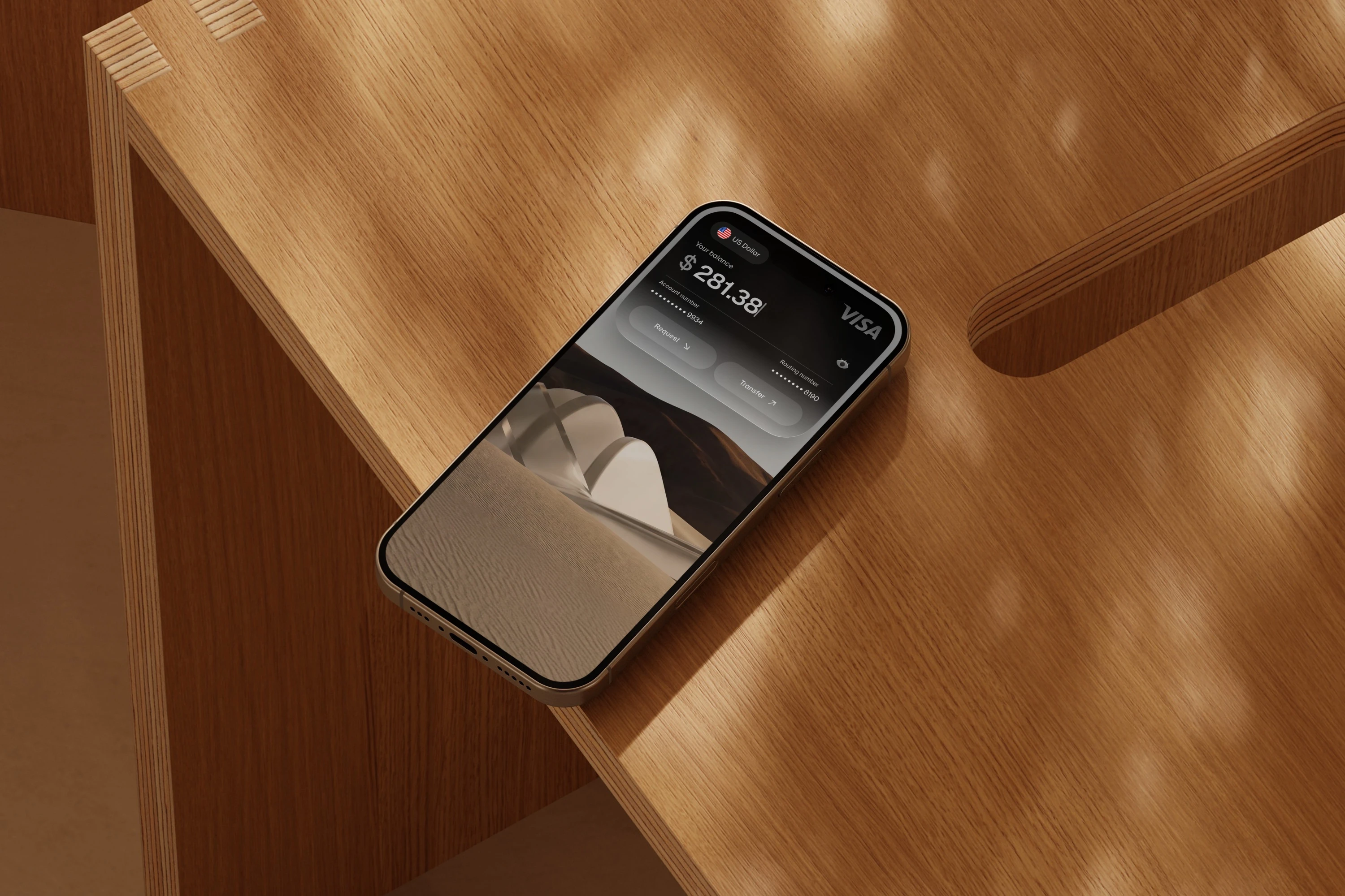 A phone on a wooden desk showing a US dollar balance in the Grain app